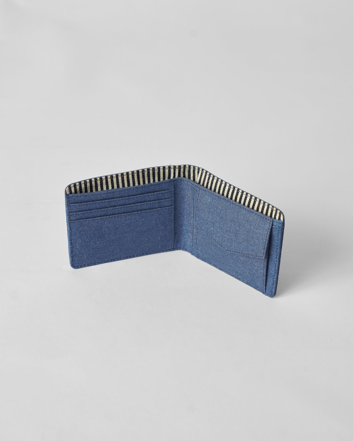 Denim blue Classic Bi-Fold Wallet opened upright to show interior slots.