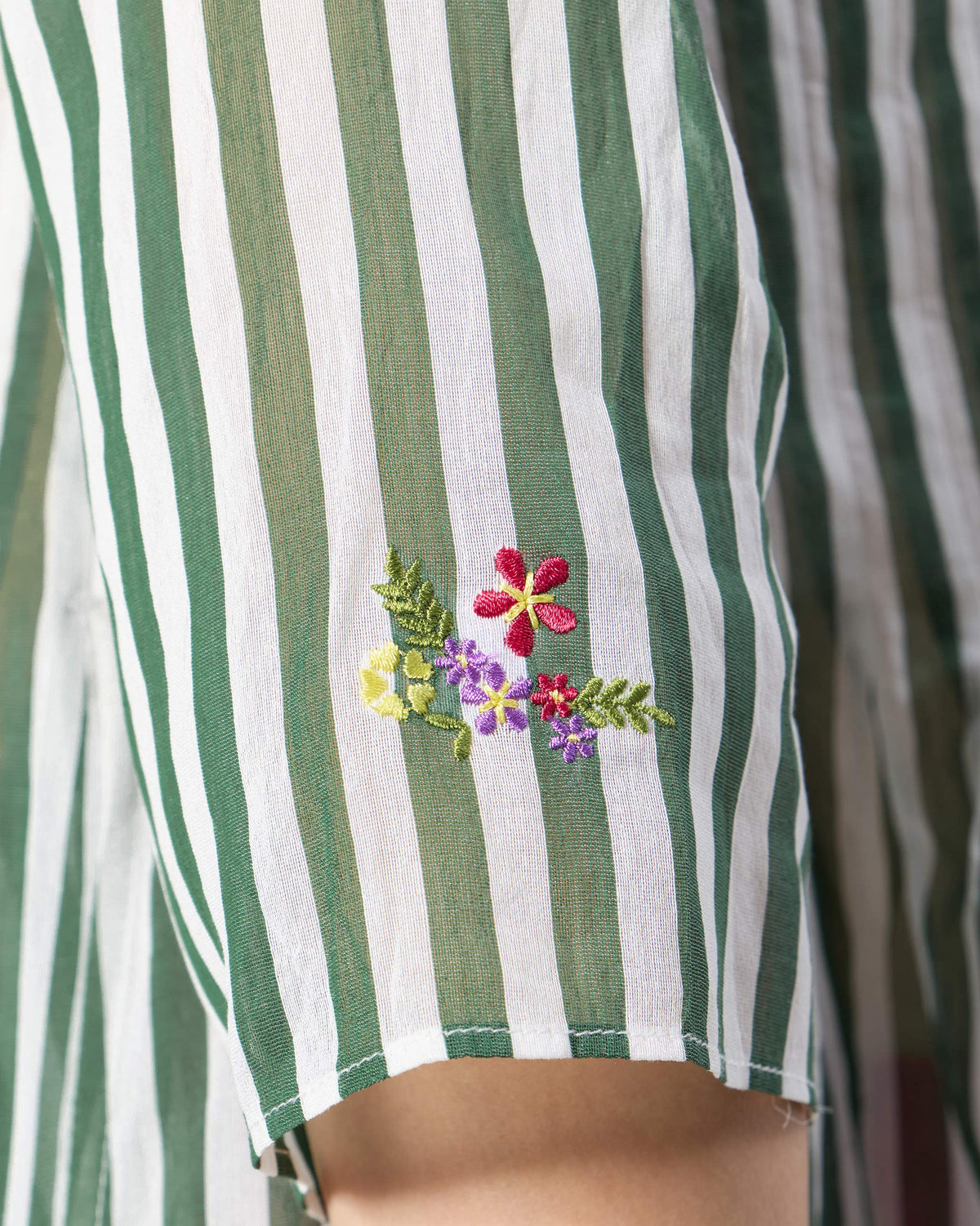 Close-up of floral embroidery on an emerald-and-ivory striped Konark kurta.