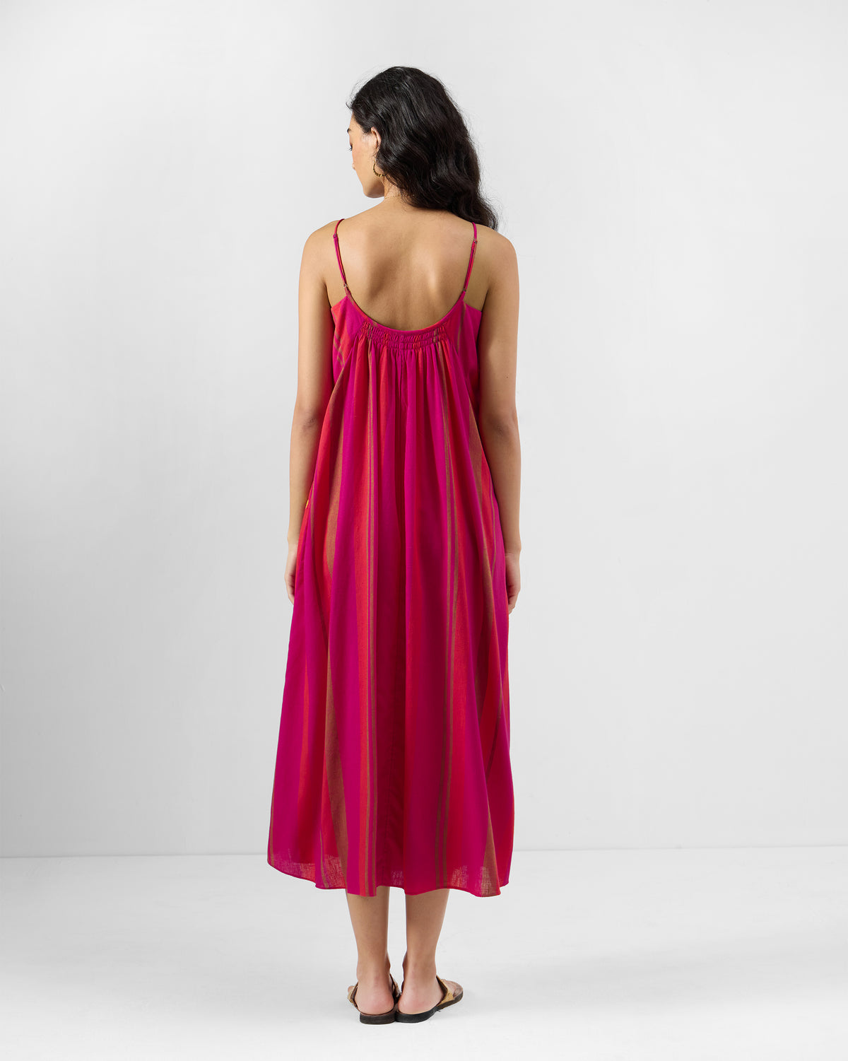 Back of a pink and orange Narali strappy dress with a low scooped back.