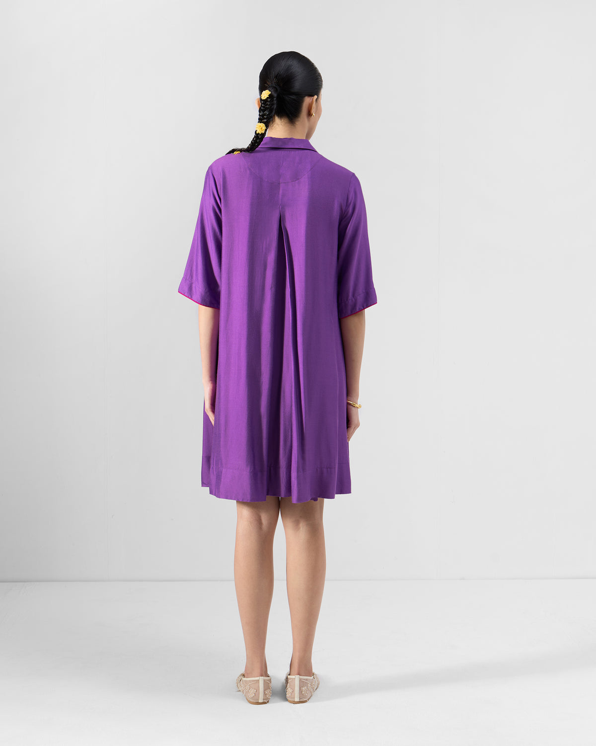 Back of a purple Happy Heart Dress with a yoke and center box pleat.