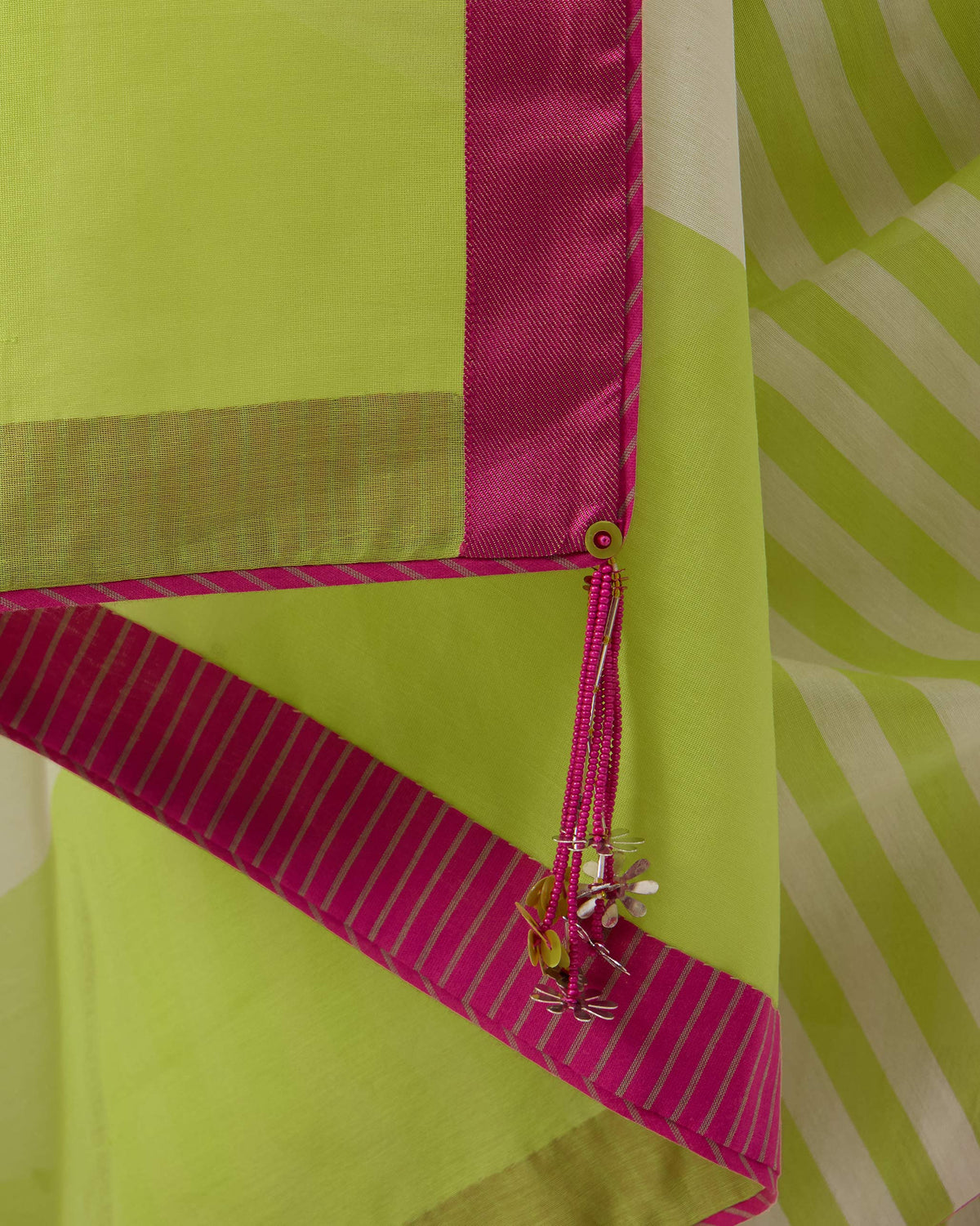 Close-up of a magenta border and beaded tassel on a Veha sari.