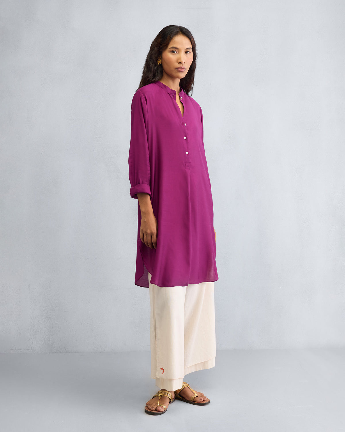 Three-quarter view of a mulberry mid-length kurta with a curved hem.