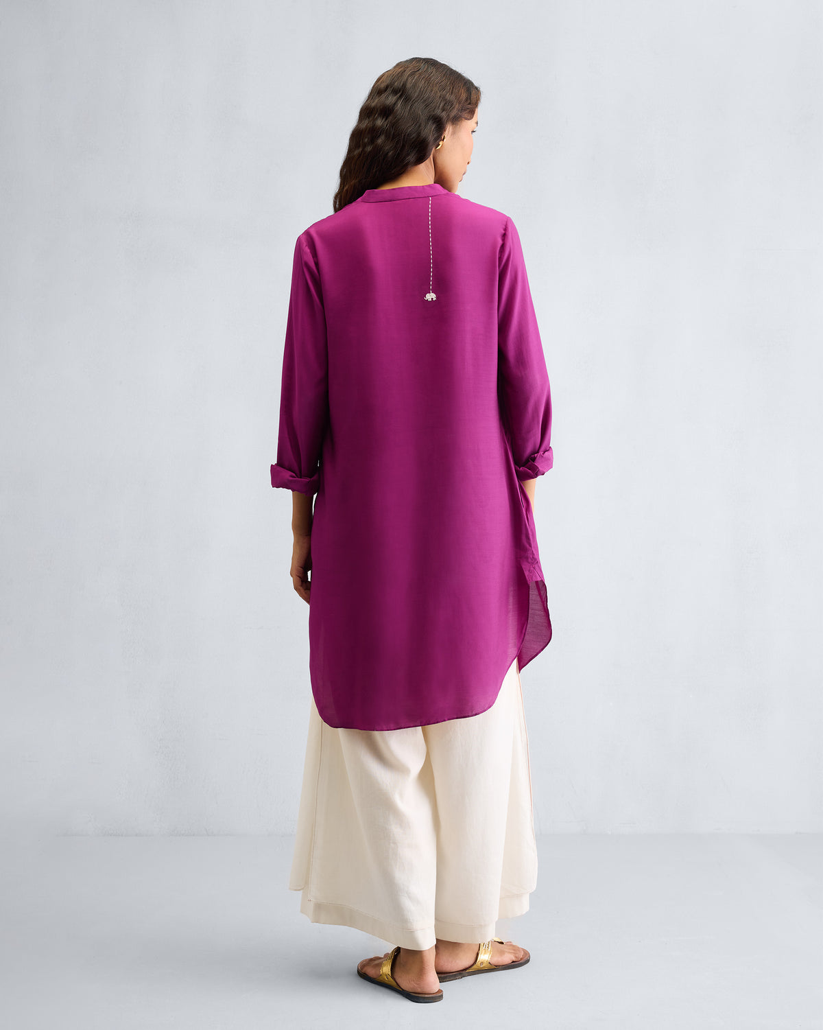 Back of a mulberry mid-length kurta with white elephant embroidery.
