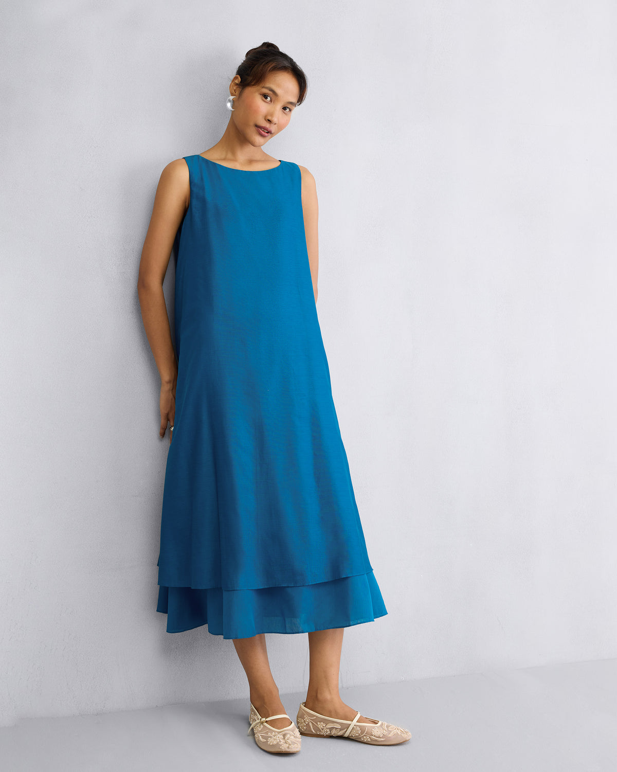 Person wearing a sapphire Double Layer Dress with a boat neck and layered hem.