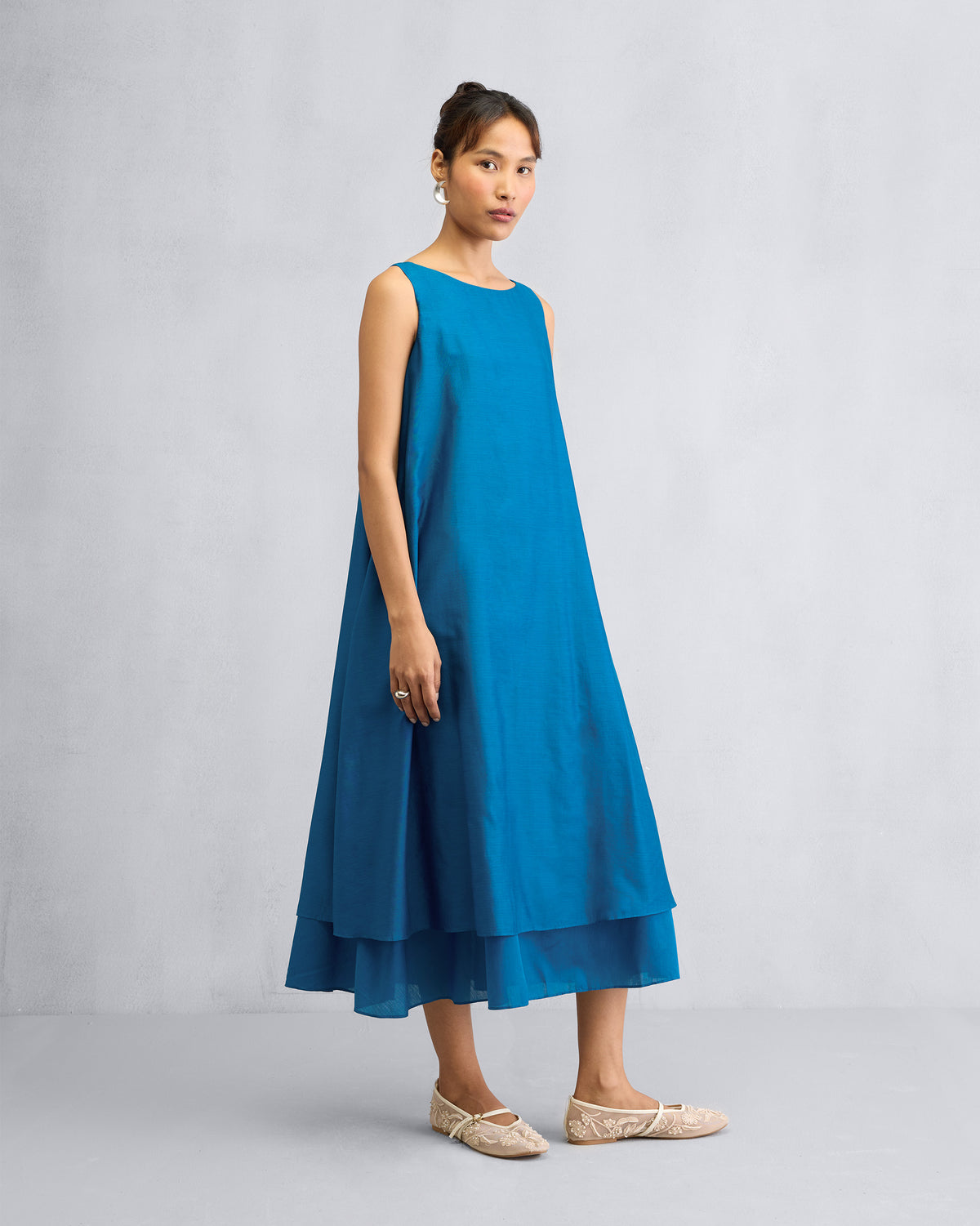 Person wearing a sapphire Double Layer Dress with a flowing A-line midi hem.