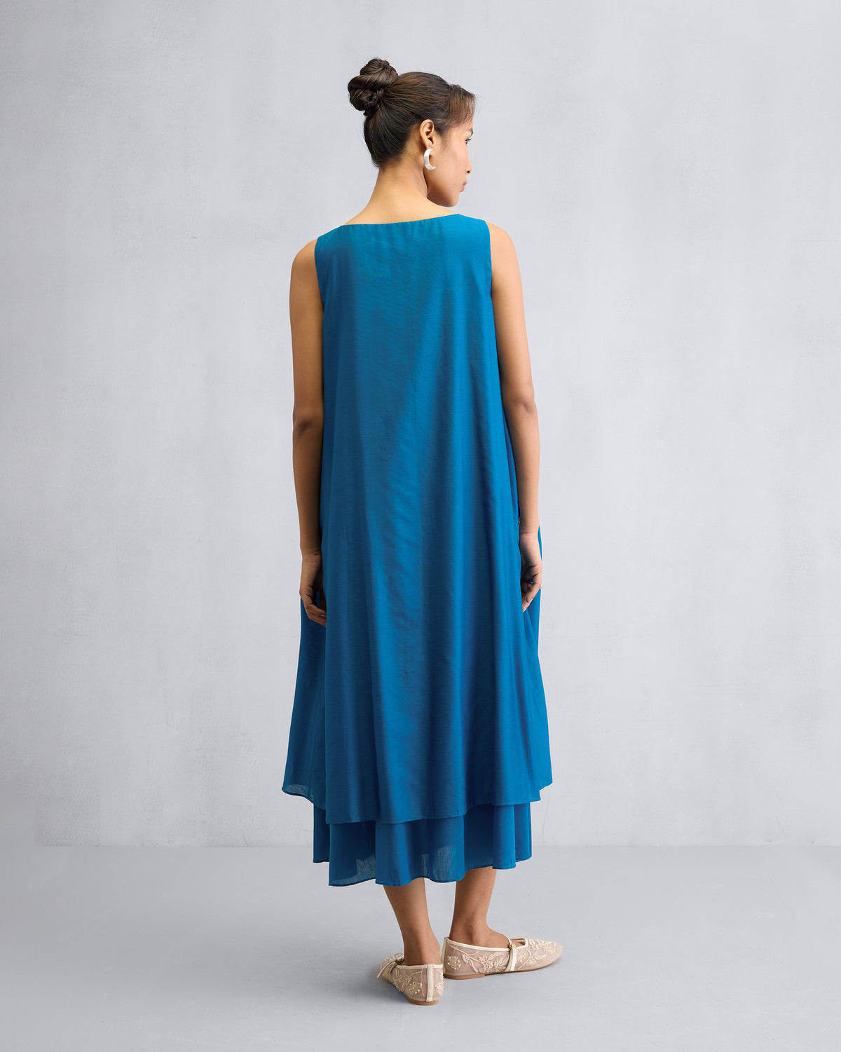 Back of a sapphire Double Layer Dress with a layered midi hem.