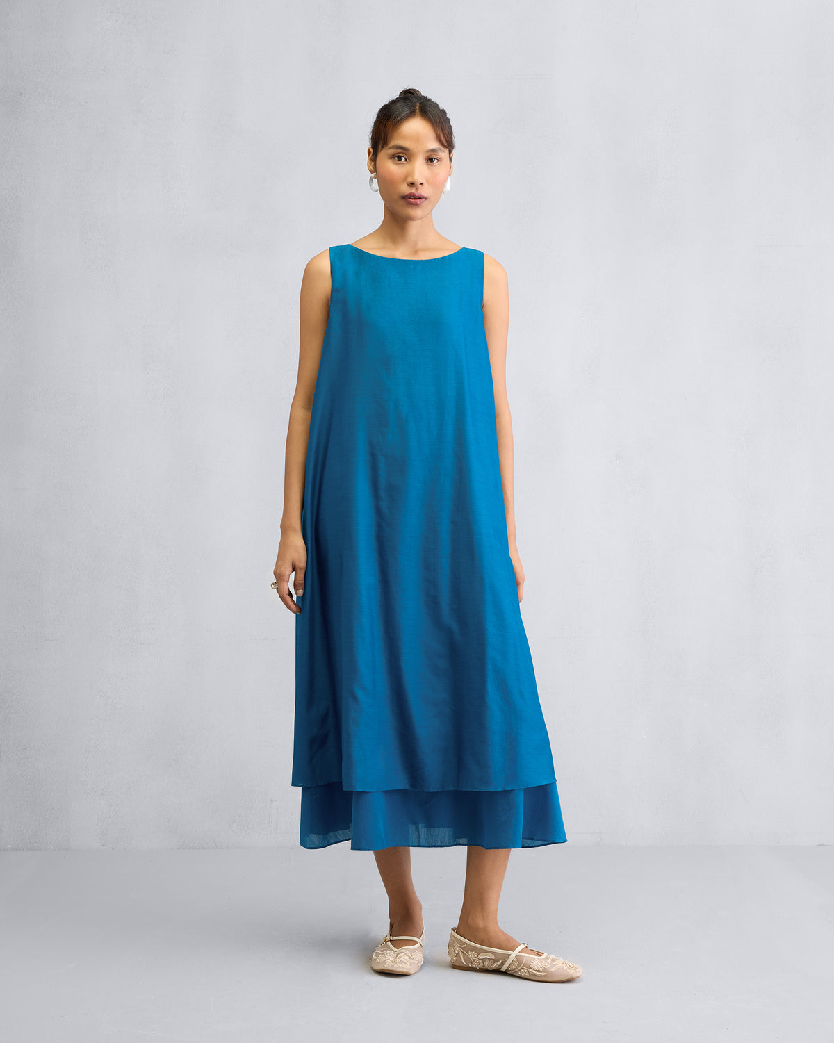 Person wearing a sapphire Double Layer Dress with a round neck and midi length.