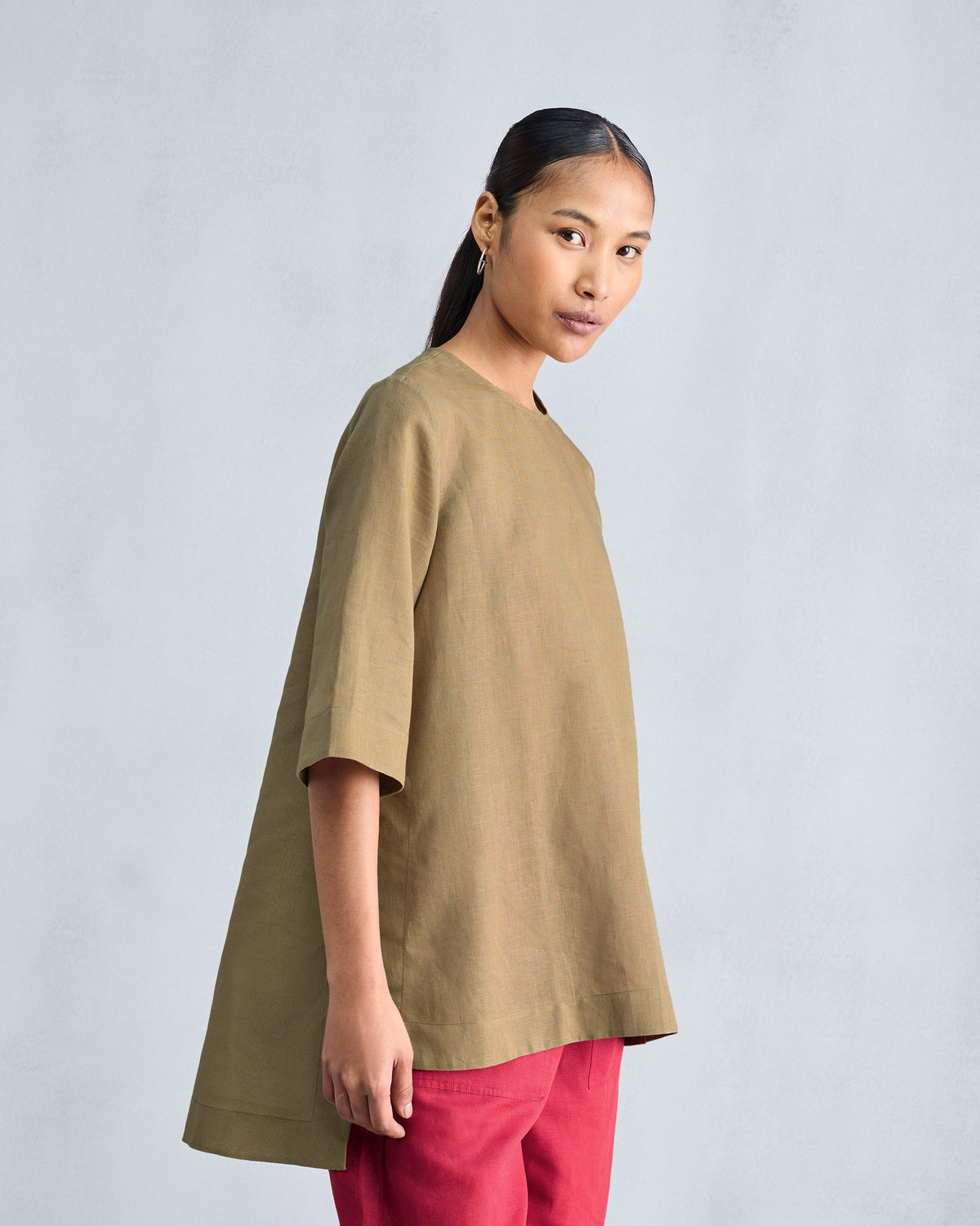 Side view of a taupe High Slit Top showing a deep side slit.