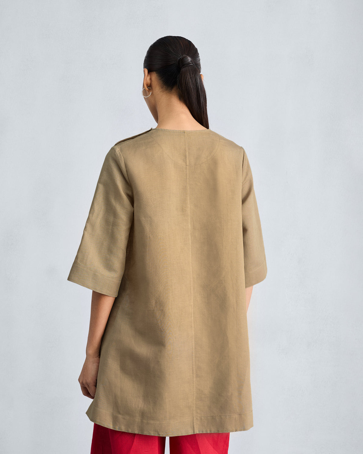 Back of a taupe High Slit Top with a clean center seam.
