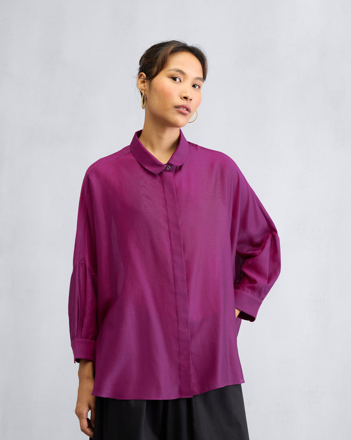 Person wearing a mulberry boxy shirt with a rounded collar and side pocket.