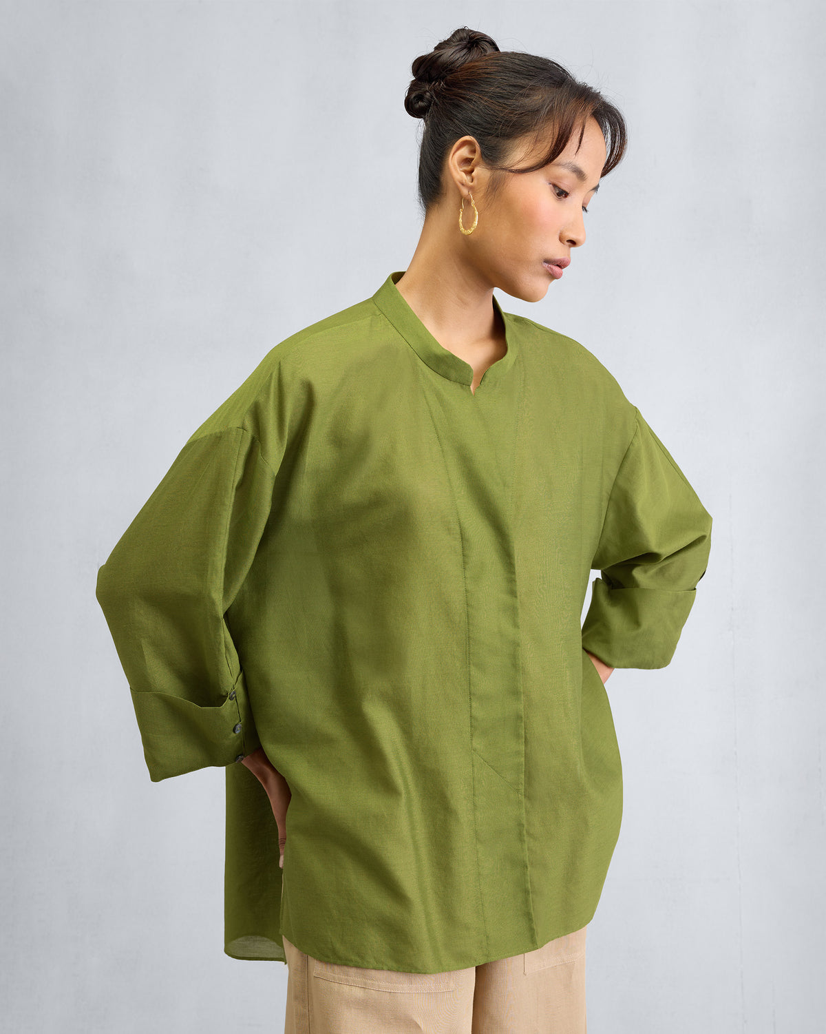 Person wearing an olive Cirrus shirt with a mandarin collar.