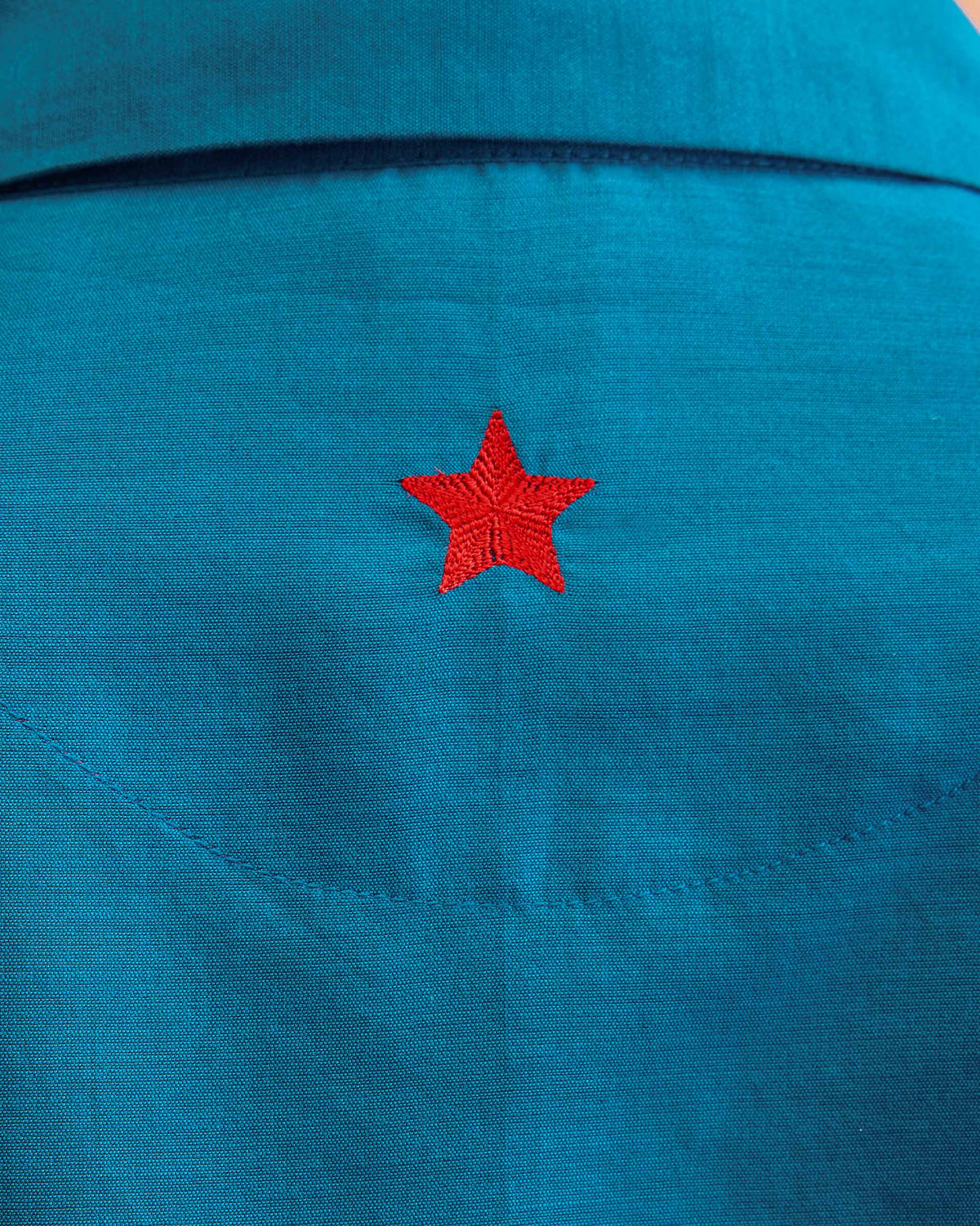 Close-up of red star embroidery on the back of the sapphire Hala tunic.