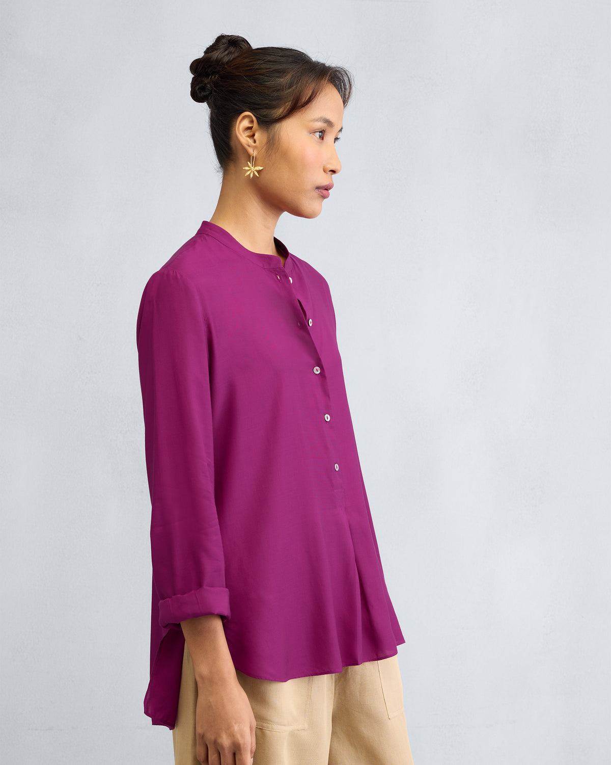 Side view of a mulberry mandarin collar top with a curved hem.