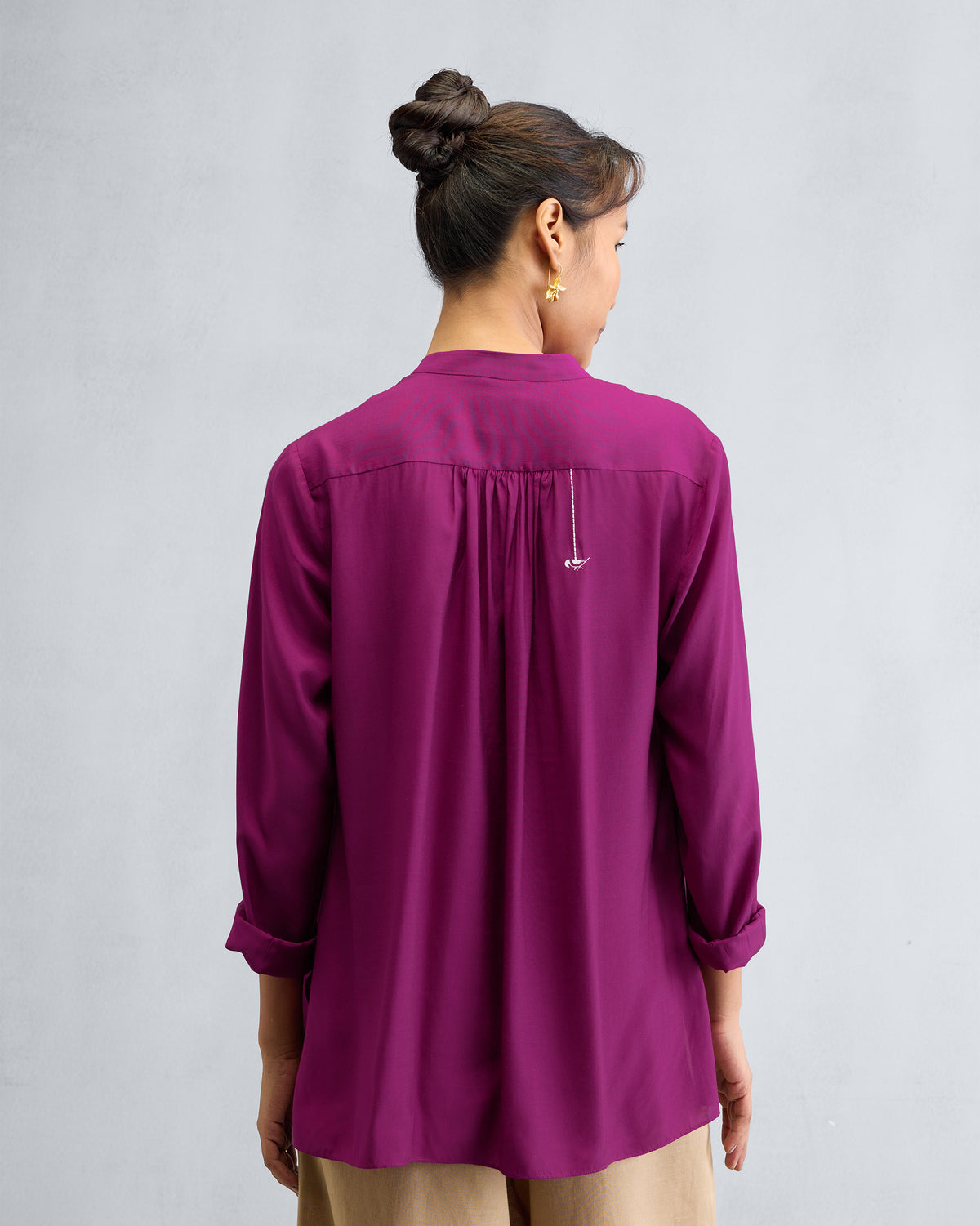 Back of a mulberry mandarin collar top with gathers at the yoke.