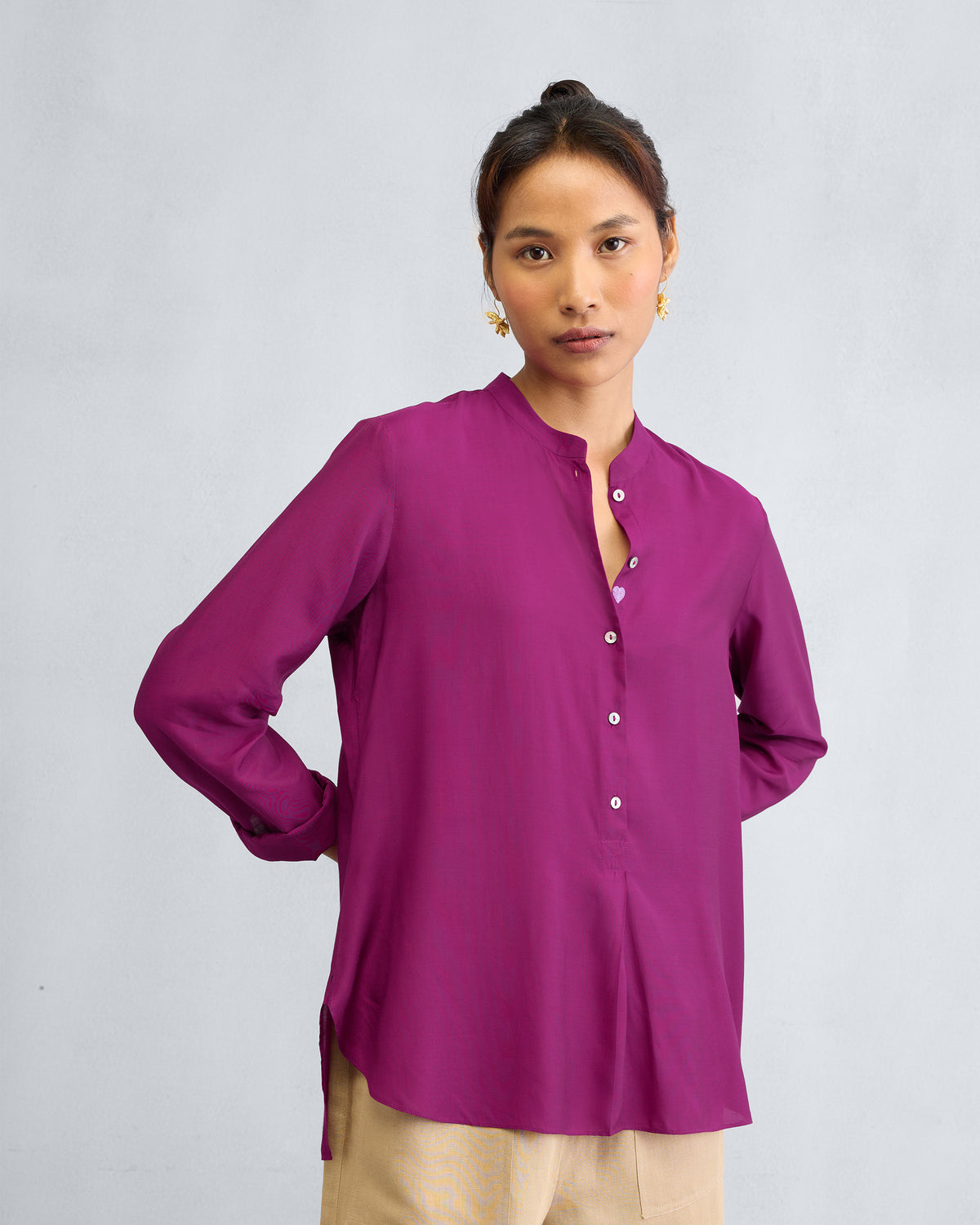 Person wearing a mulberry mandarin collar top.