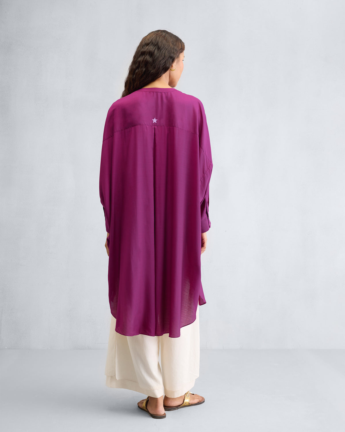 Back of a mulberry Lazy Sunday tunic with a box pleat and embroidered star.