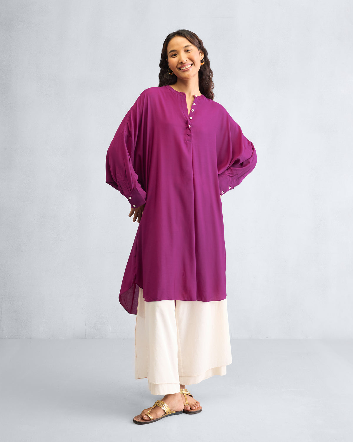Person wearing a mulberry Lazy Sunday tunic with voluminous balloon sleeves.