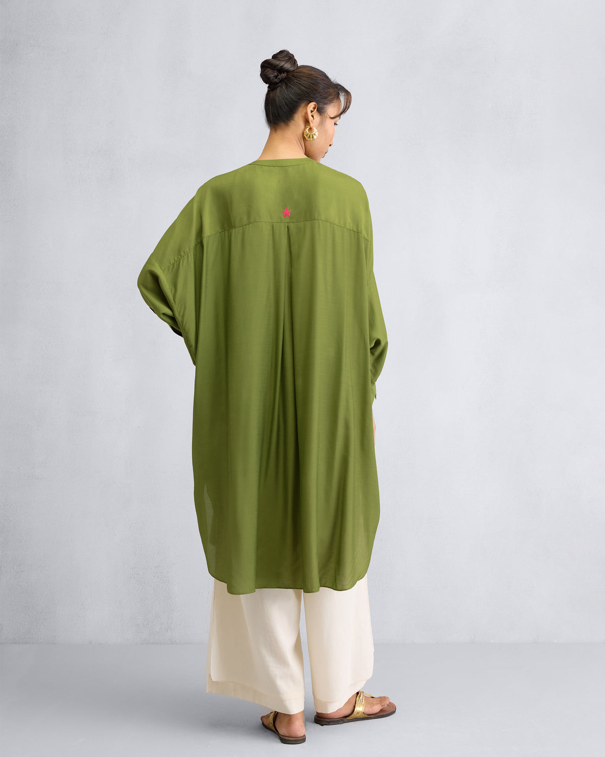 Back of an olive Lazy Sunday tunic with a pink embroidered star.