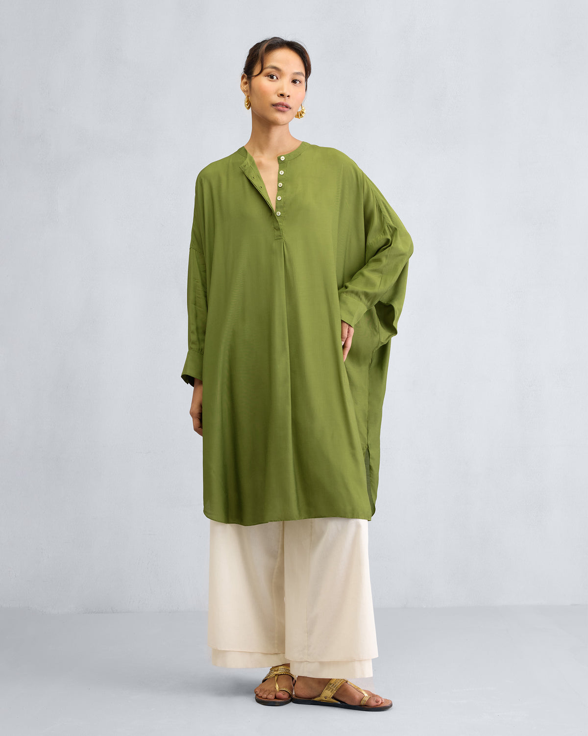Person wearing an olive Lazy Sunday tunic with a fluid drape.