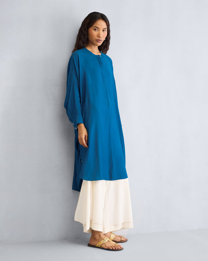 Person wearing a teal Lazy Sunday tunic with a high-low hem.