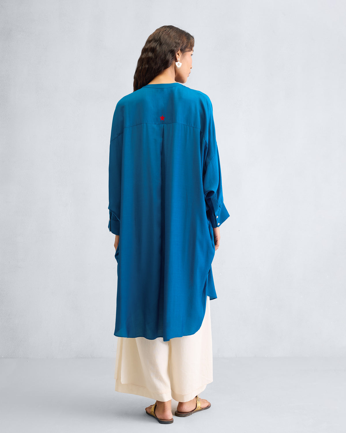 Back of a teal Lazy Sunday tunic with a box pleat and longer hem.
