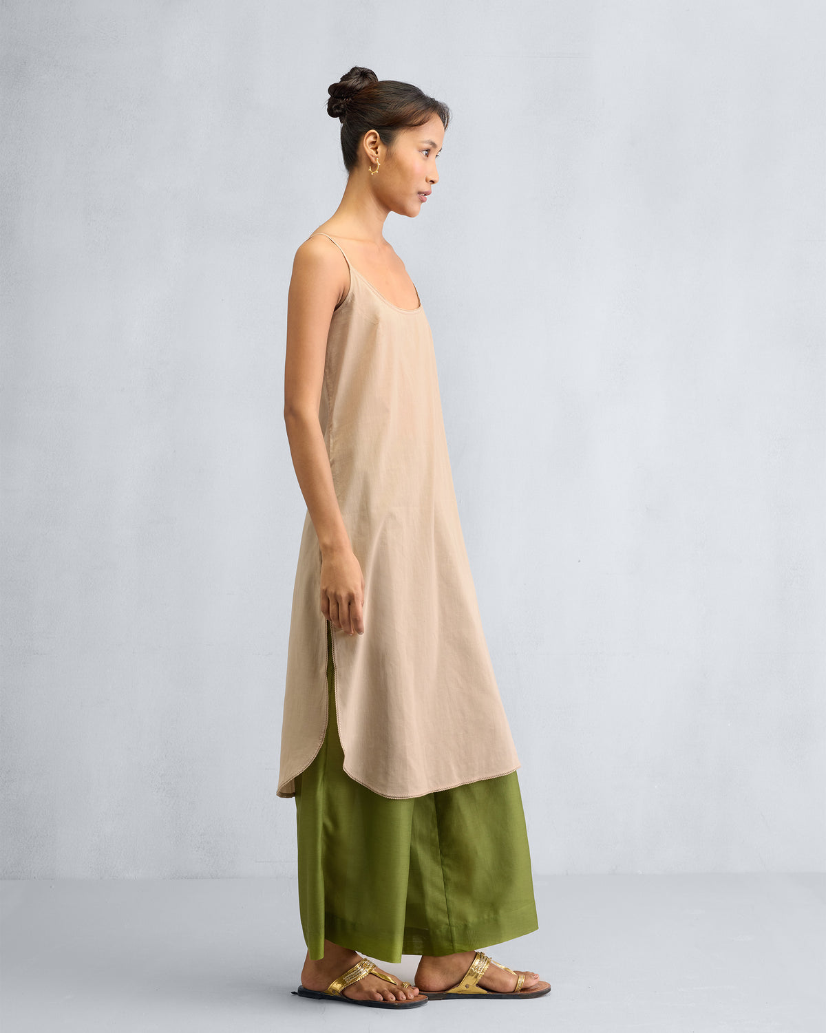 Side view of a sand Vintage Camisole showing its side slits and length.