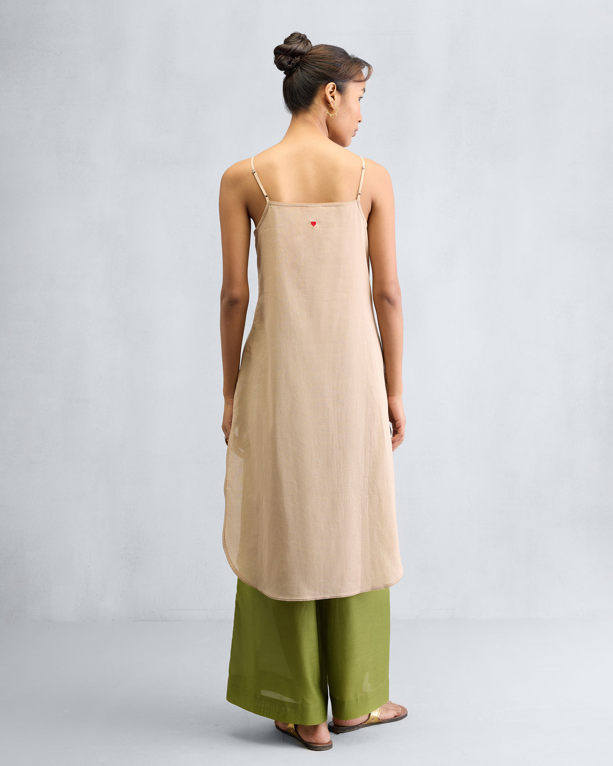 Back of a sand Vintage Camisole with a small red heart embroidered near the top.