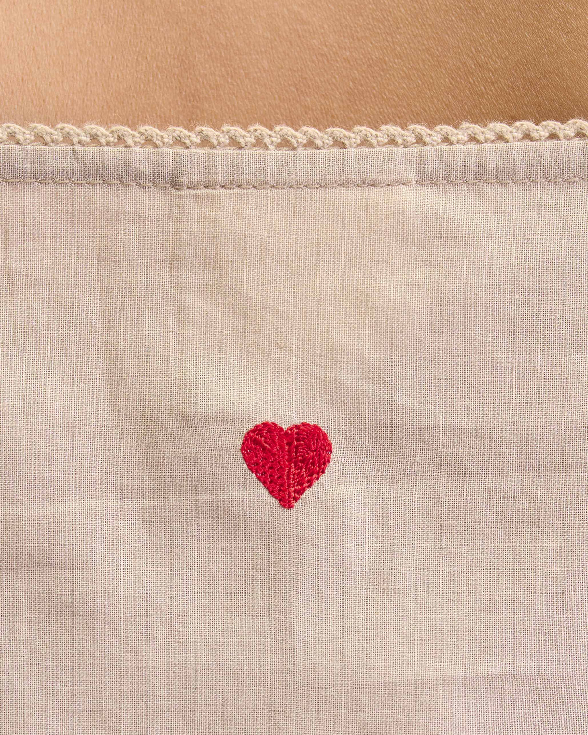 Close-up of a sand Vintage Camisole showing a small red embroidered heart.