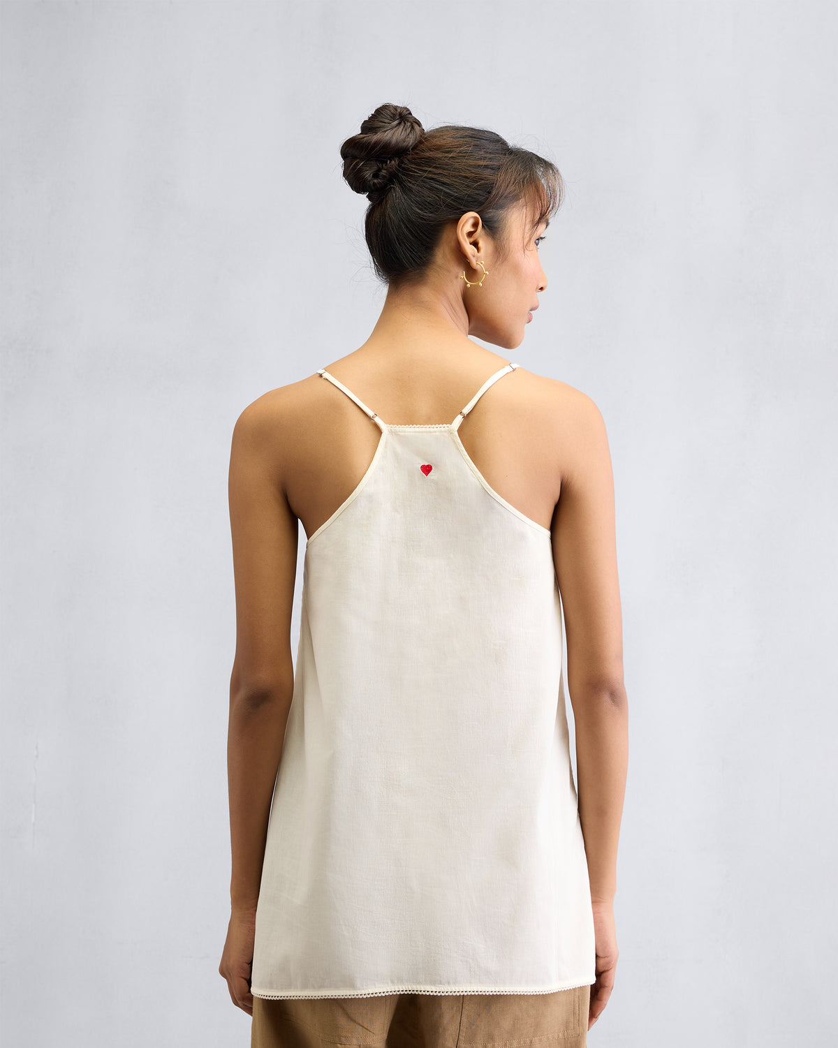 Back of an ivory Afra Camisole with a red heart embroidered at the centre.