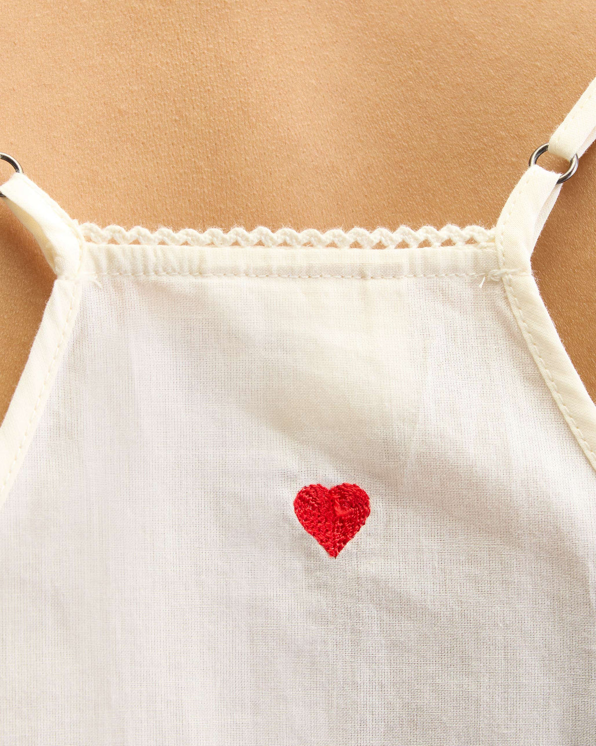 Close-up of an ivory Afra Camisole showing a red embroidered heart.