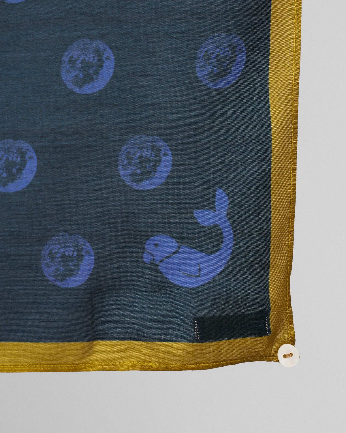 Close-up of Rhythm Scarf corner showing blue moon and whale motifs with a yellow border.