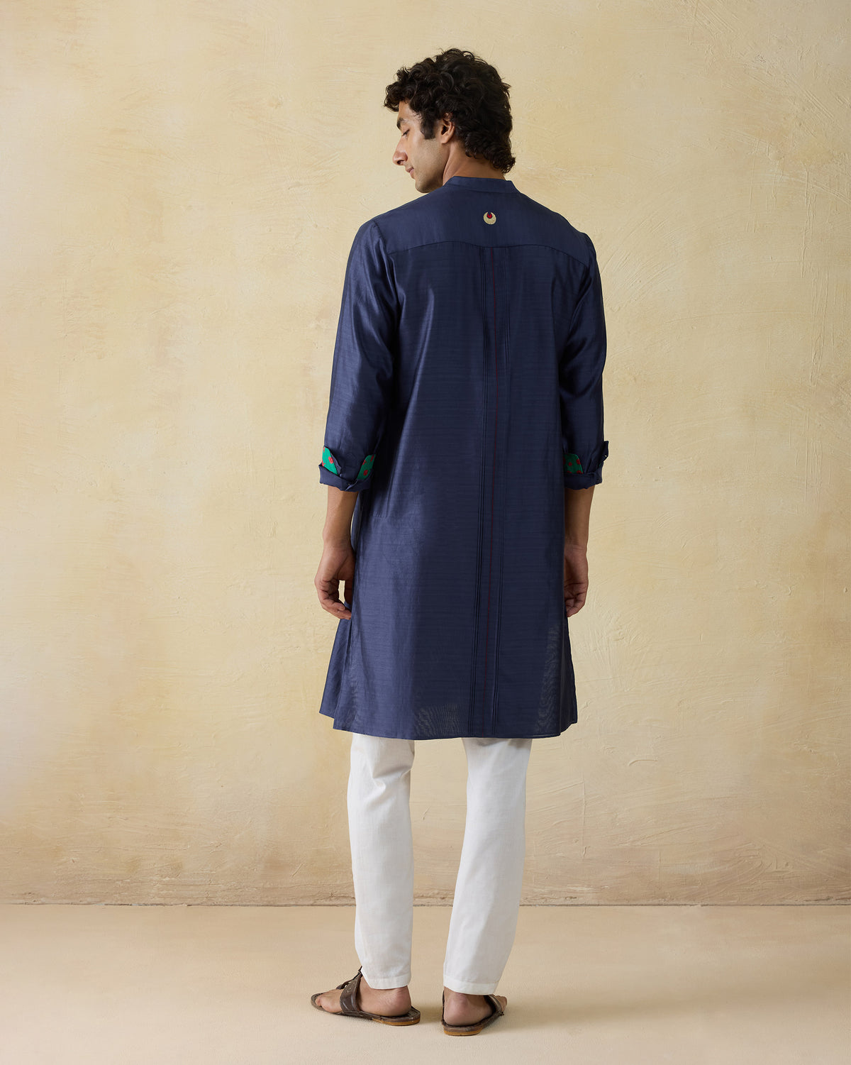 Back of a navy Naaz kurta with a gold crescent at the yoke.