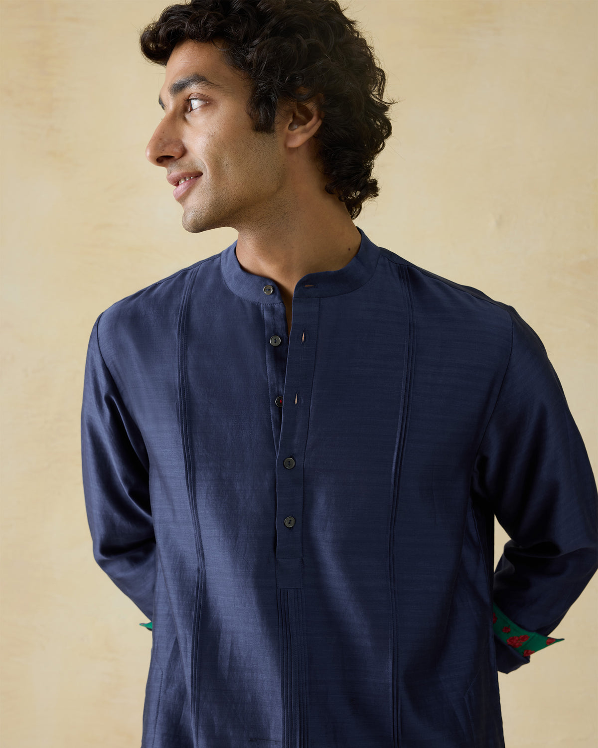 Person wearing a navy Naaz kurta with front pintucks.