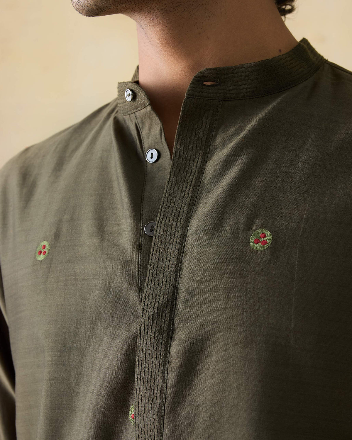 Close-up of an olive green Neckband Kurta showing the pintucked collar and embroidery.