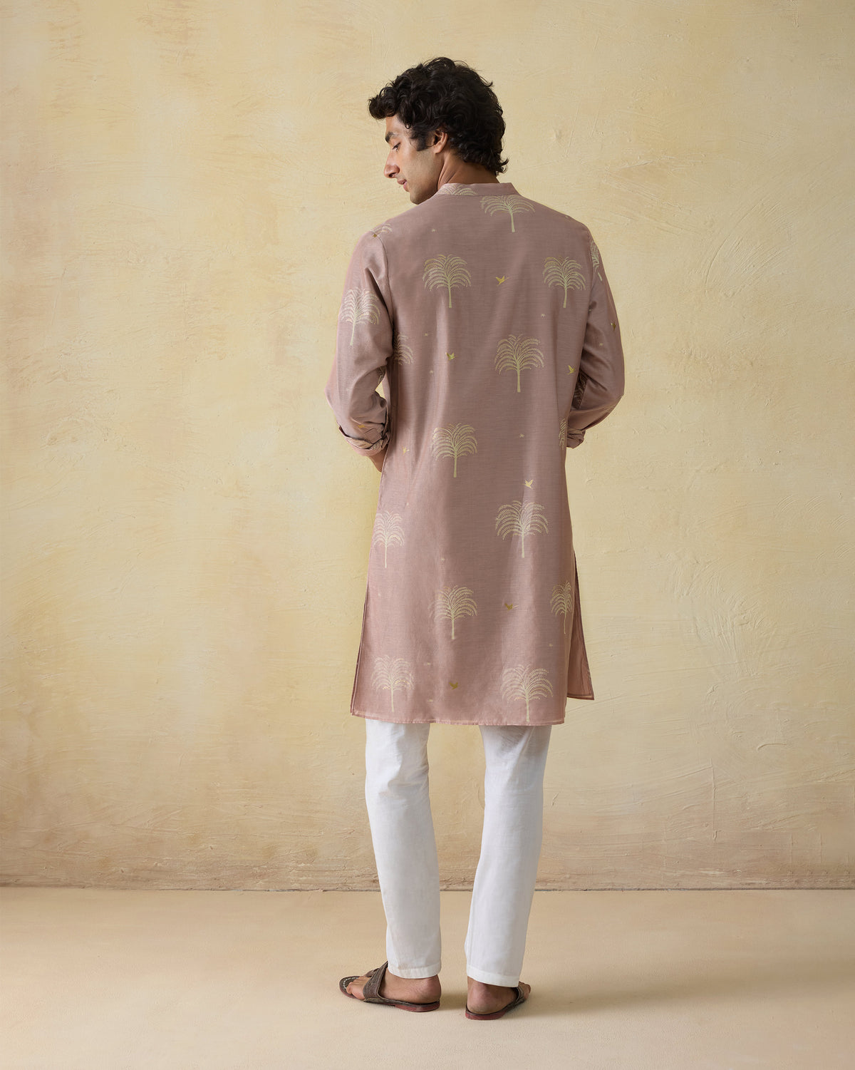 Back of a light pink Bageecha kurta with gold palm-tree print.