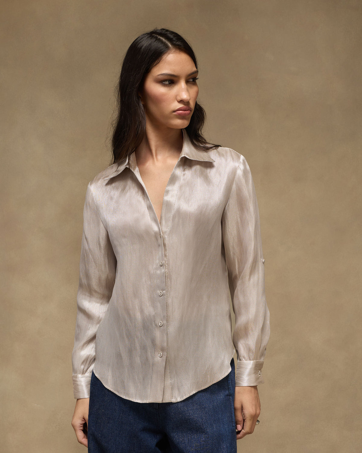 Person wearing a silver tissue organza shirt with a pointed collar.