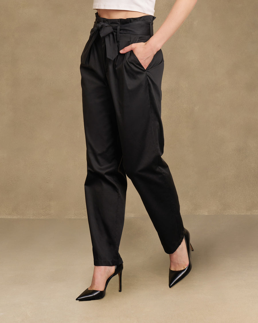 Side view of the Gumdrop Pants with a hand in the pocket, worn with pointed black heels.