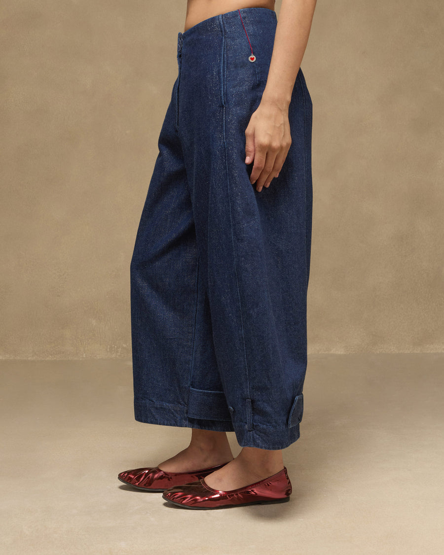 Side view of the Groove Pants, showing the curved seams and a red-stitched detail at the hip.
