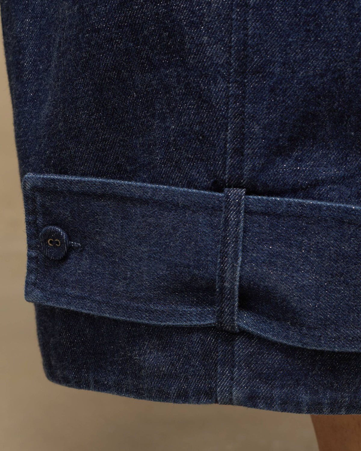 Close-up of navy Groove Pants showing a button-tab cuff.
