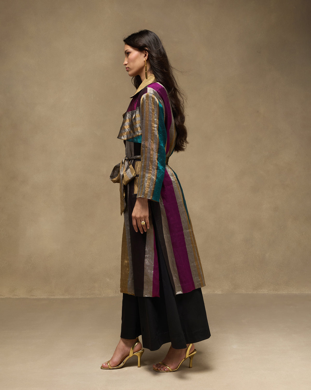 Side view of a multicolour metallic striped trench with a waist belt.