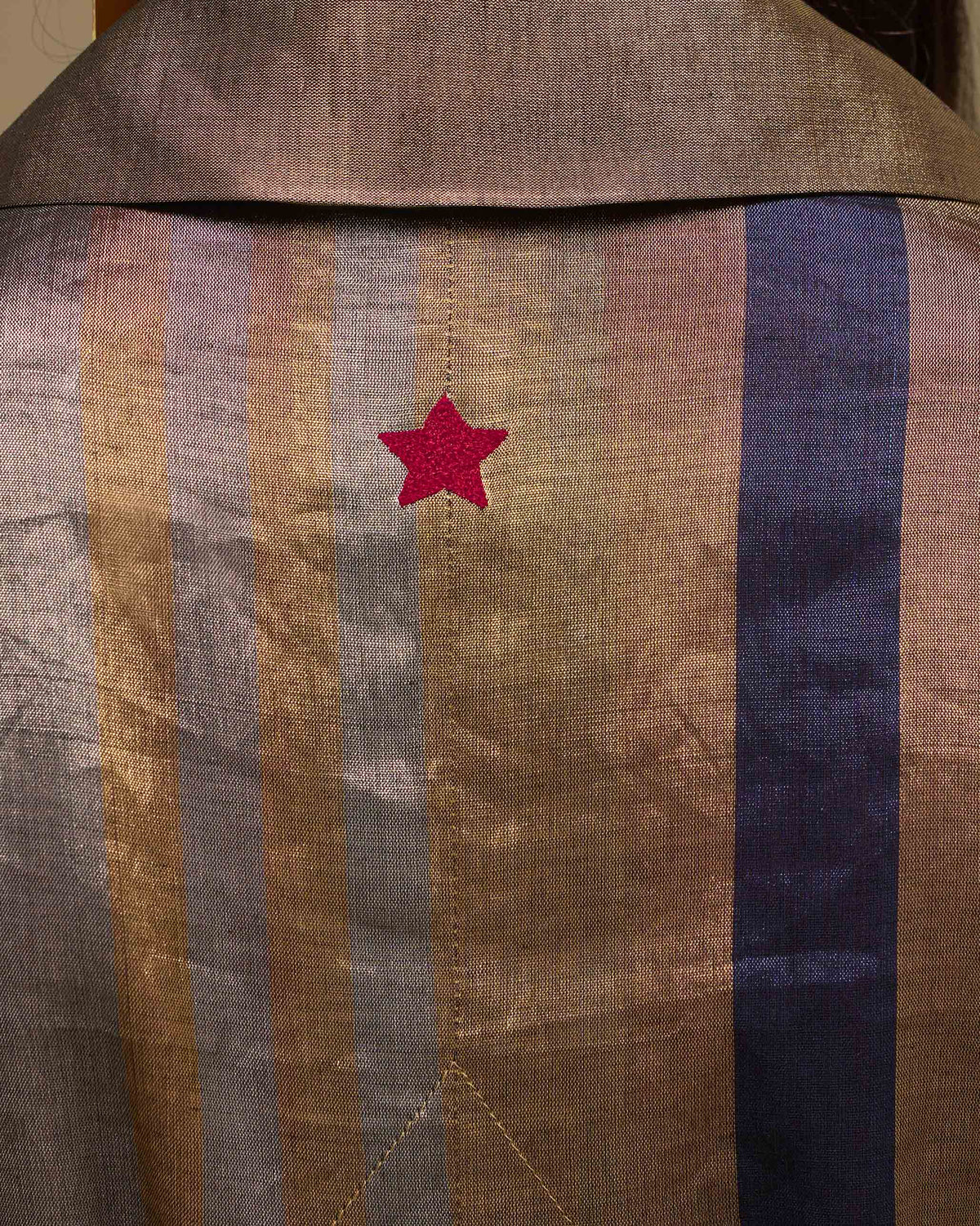 Close-up of a metallic striped trench with a red embroidered star.