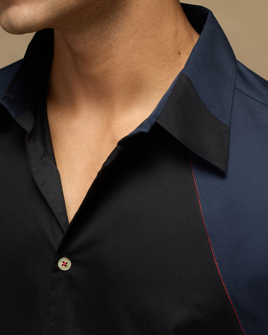 Close-up of the collar of the Moonrise Shirt, where black and navy cotton satin meet along a seam stitched in dark red.