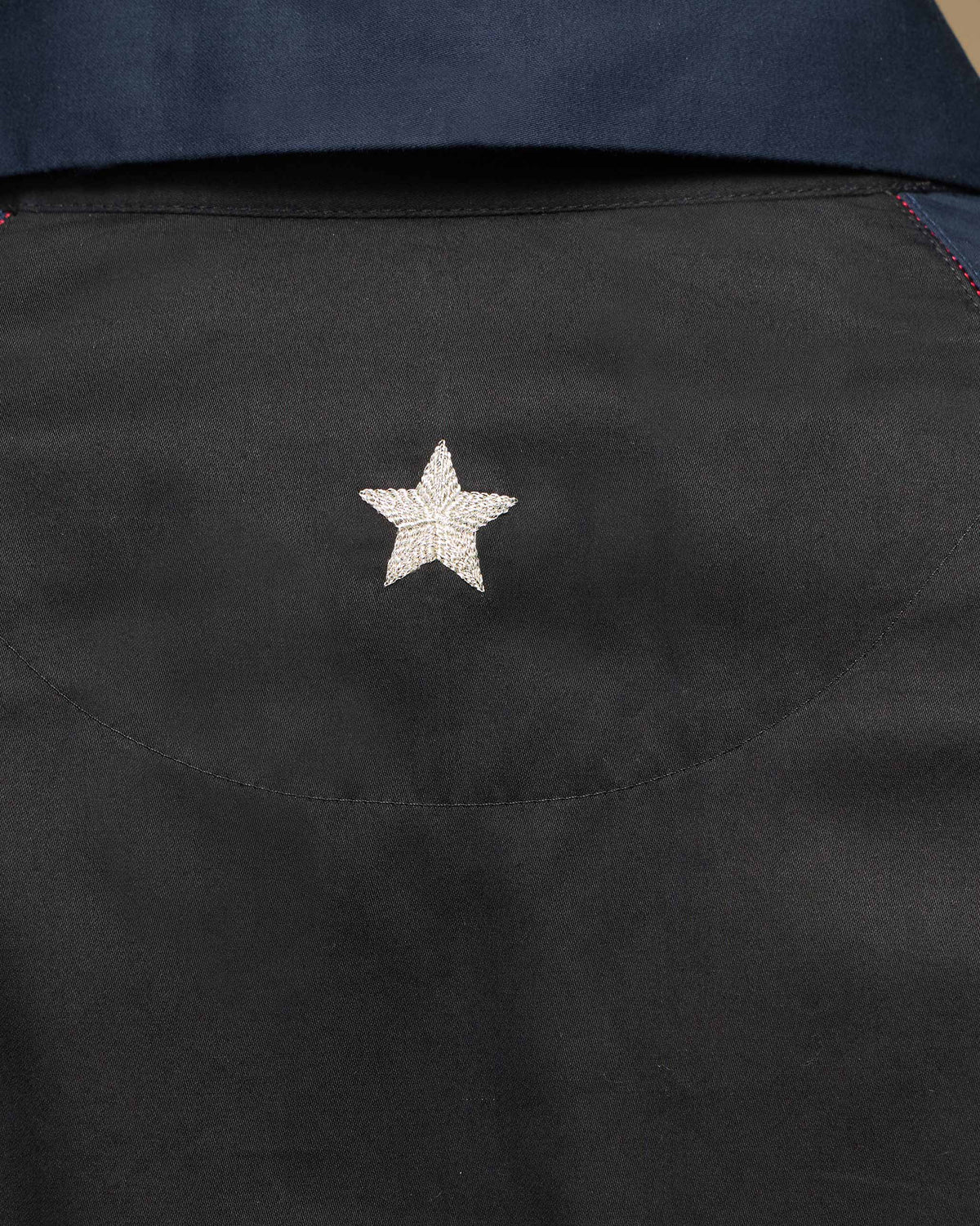 Close-up of a silver star on the back of a Moonrise shirt.