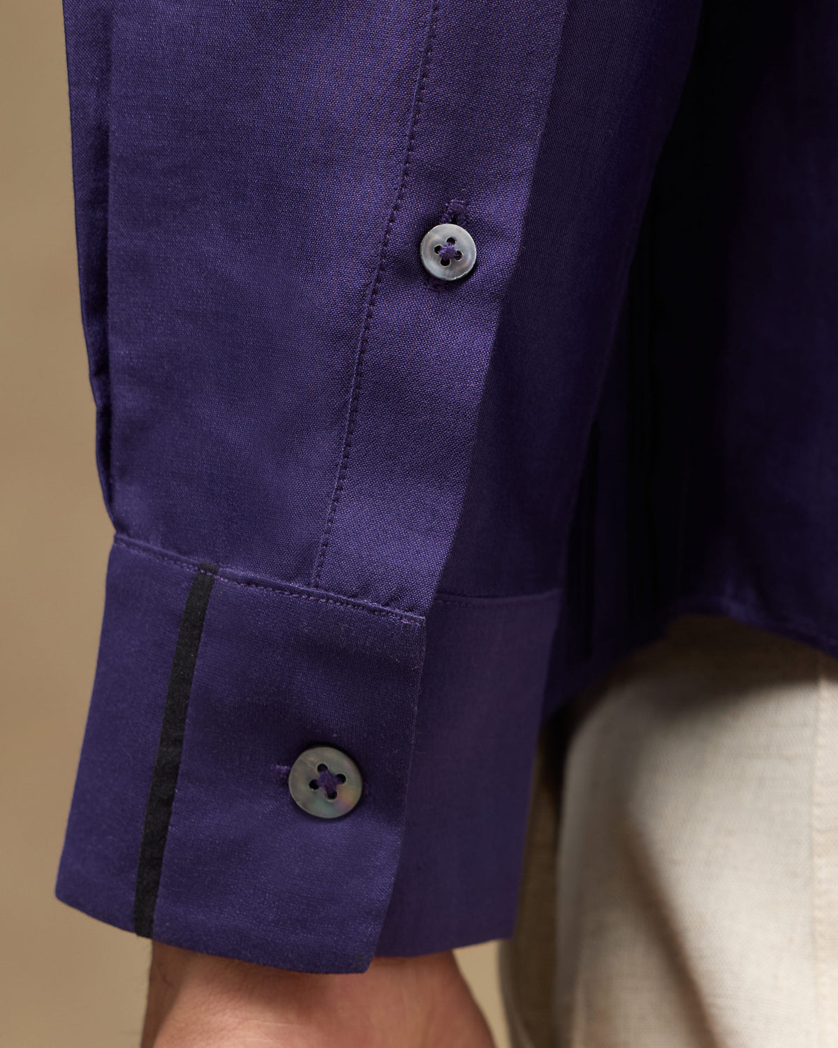 Close-up of Sundown Shirt cuff with pearl buttons and black piping.