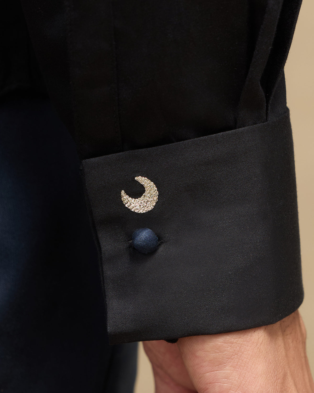 Close-up of a black Midnight Shirt cuff with a crescent moon.
