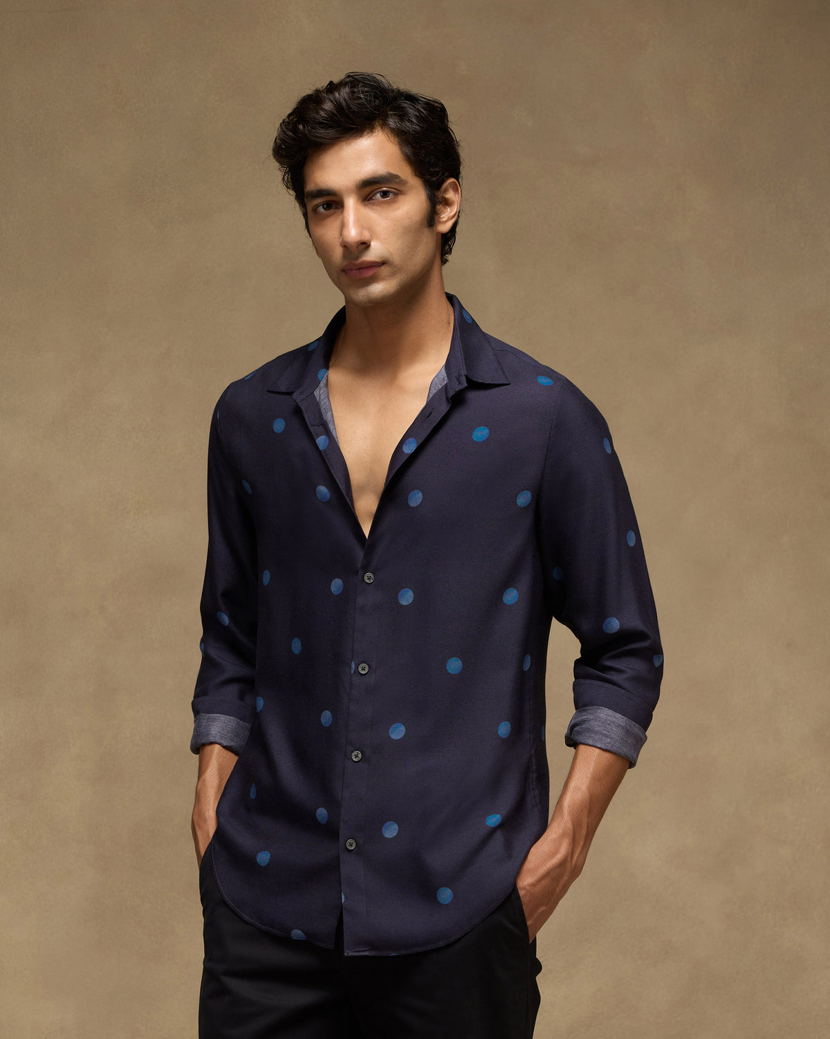 Person wearing a dark navy Daze shirt with a blue dot print.