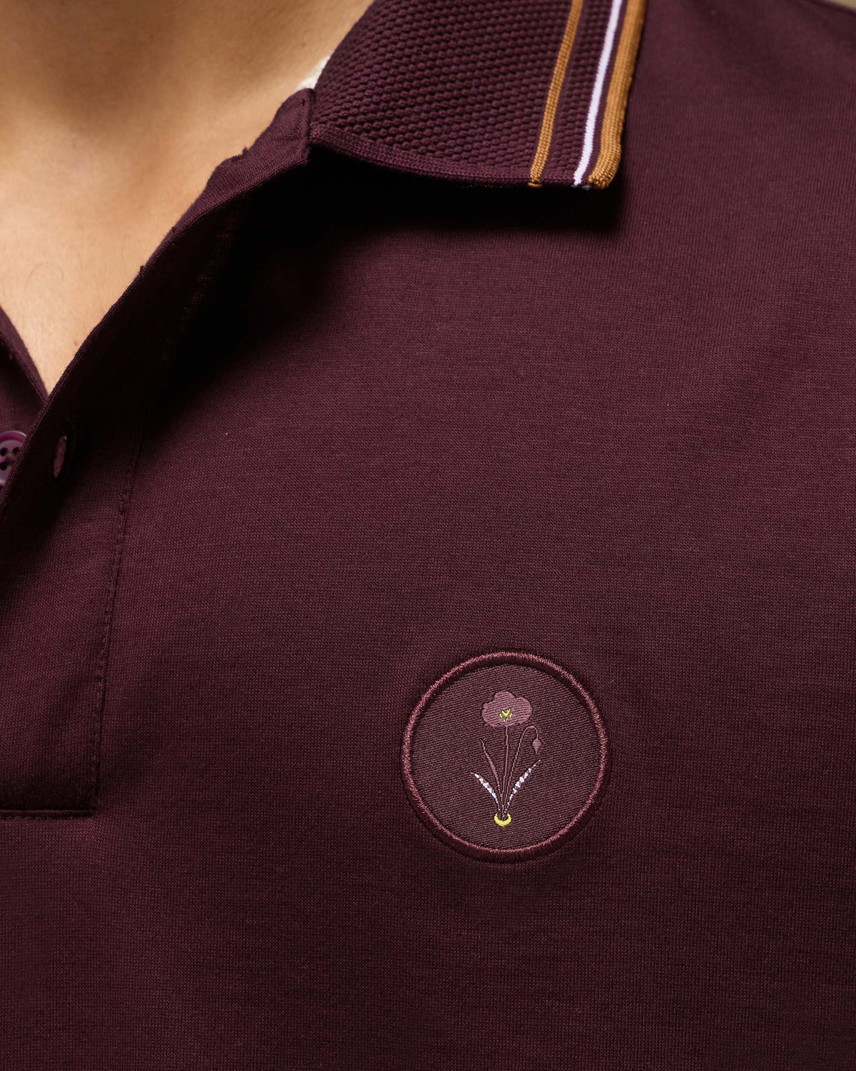 Close-up of the embroidered chest crest on a maroon Stag Polo.