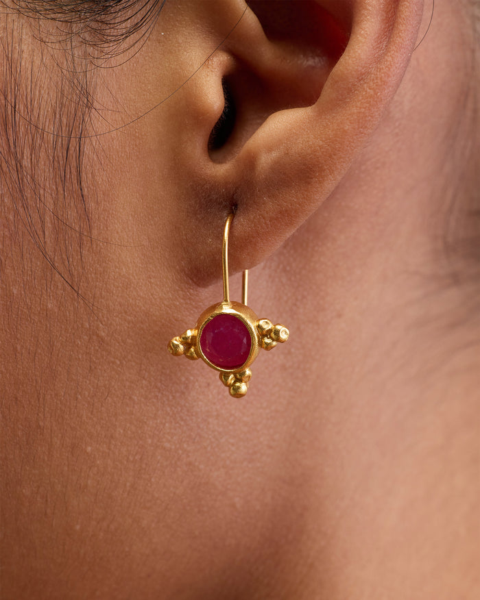 Close-up of Pink Jade Drops worn on an ear, showing a pink stone.