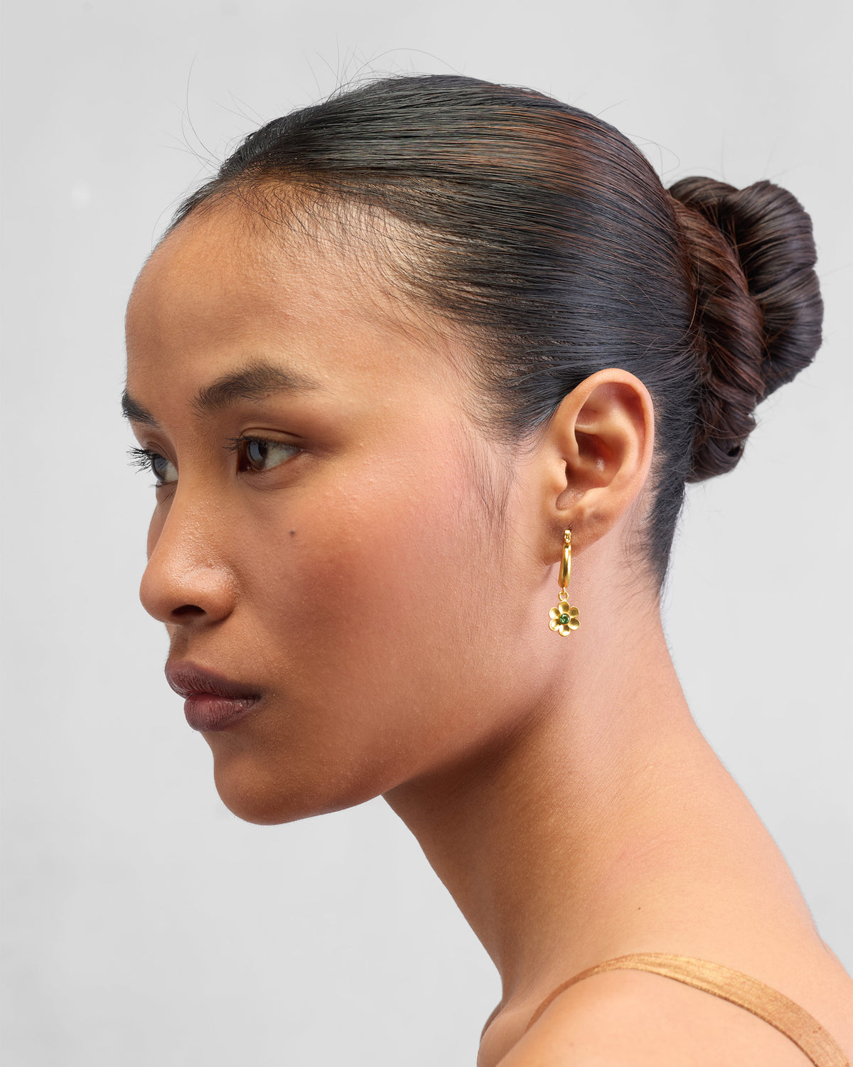 Side profile of gold Raat Rani flower earrings on a person.