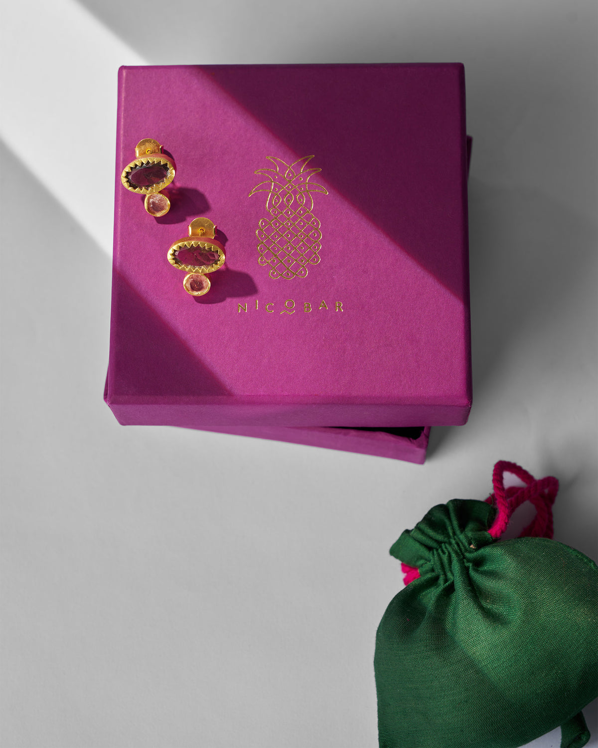 Pair of Coastline Earrings displayed on a magenta gift box.